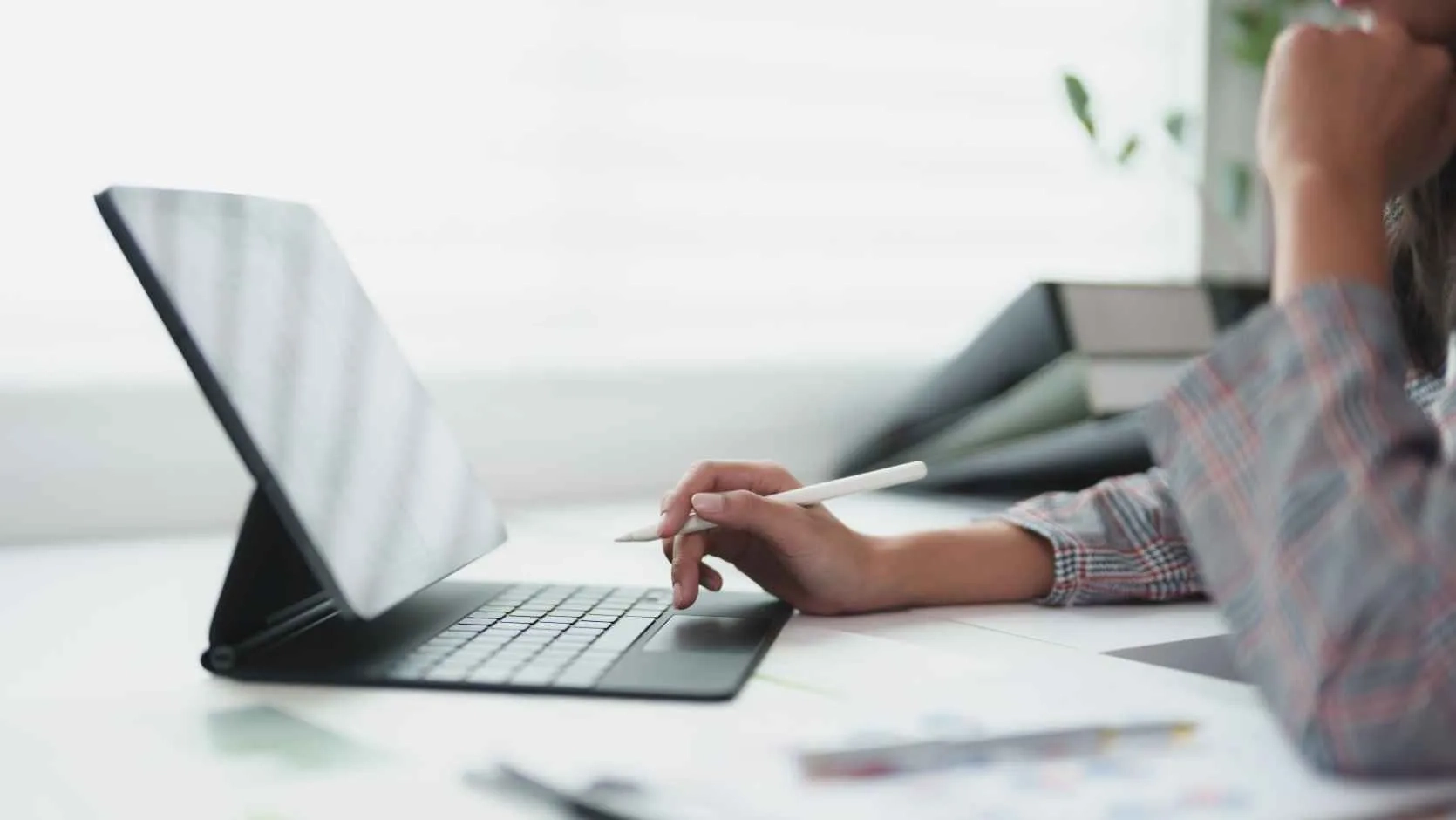 Recherche im Backoffice durch Frau am Laptop mit Stift in der Hand