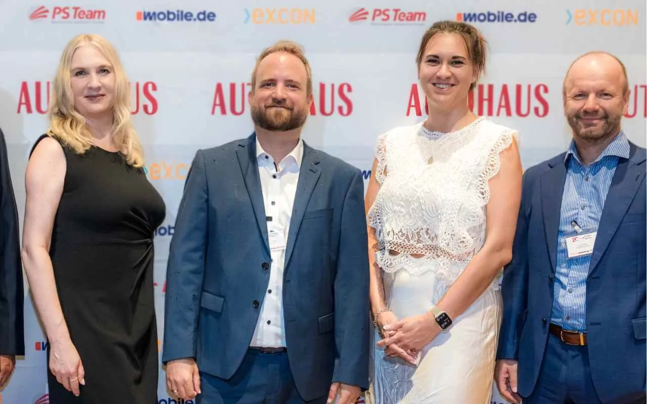 EXCON Team vor der Fotowand des AUTOHAUS BankenMonitors 2025