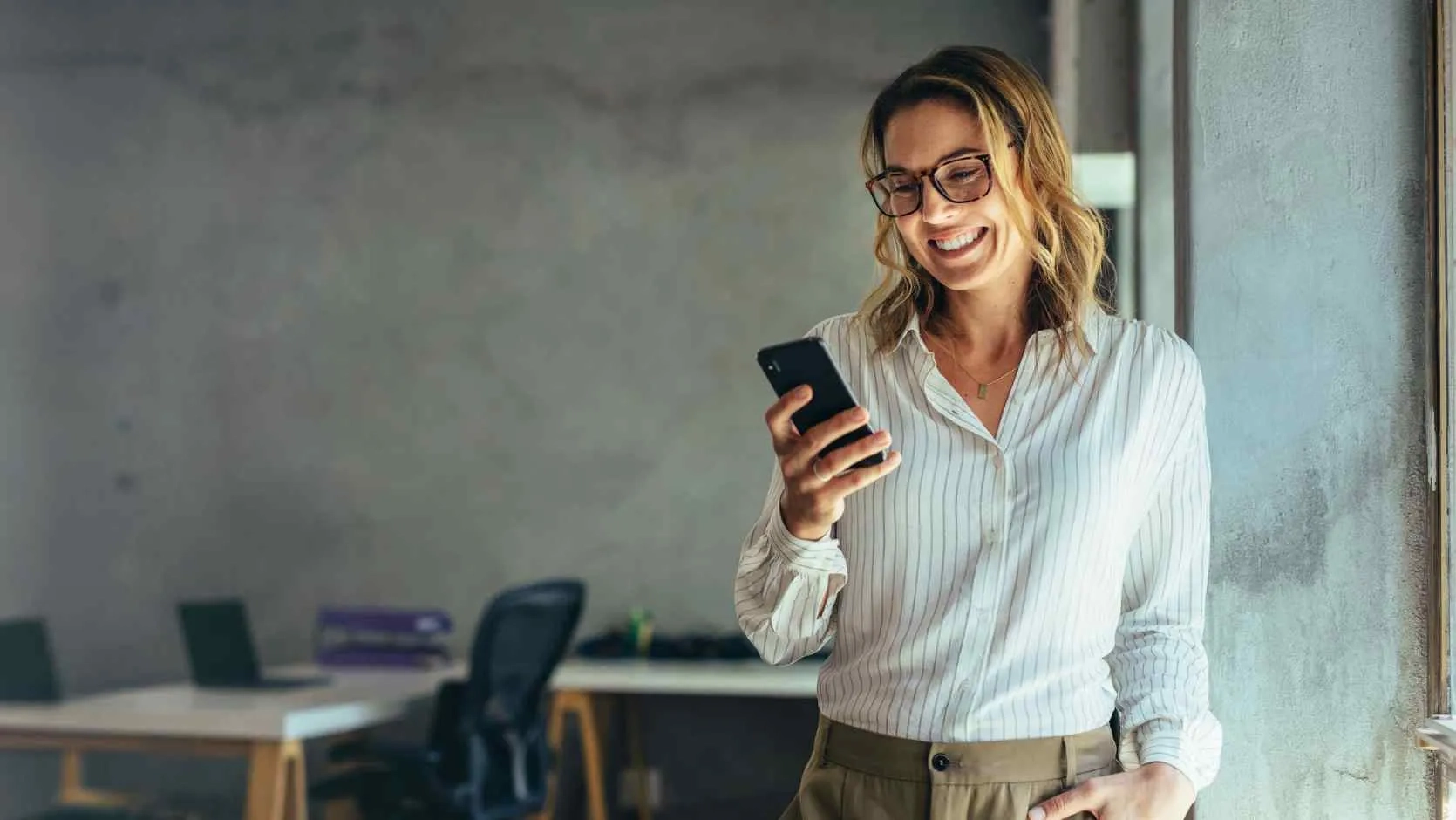 Frau mit Smartphone erhält Hilfe und lächelt