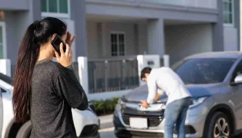 Frau ruft nach Fahrzeugschaden bei Versicherung an