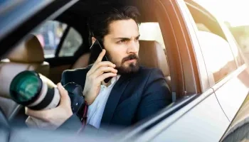 Vor-Ort-Ermittlungen durch einen Mann im Auto mit Smartphone und Kamera