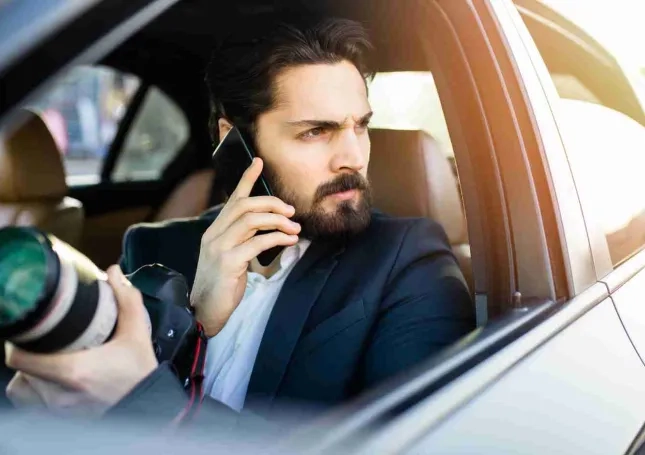 Vor-Ort-Ermittlungen durch einen Mann im Auto mit Smartphone und Kamera