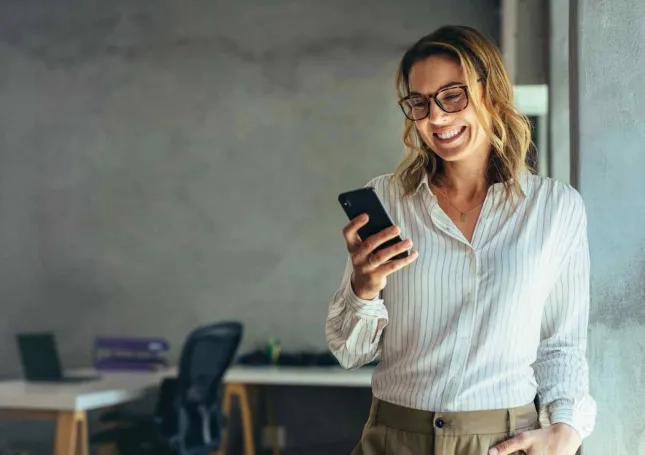 Frau mit Smartphone erhält Hilfe und lächelt